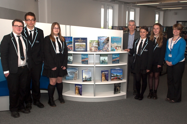 Richard Webb, Liz Wilson and Dartmouth Academy students around the display of books that Mr Webb has donated to the new Academy library
